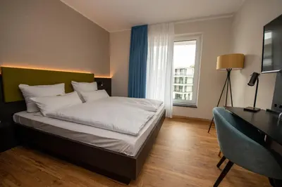 Ein Bett oder Betten in einem Zimmer der Unterkunft EINSTEIN Hotel am Römerpark