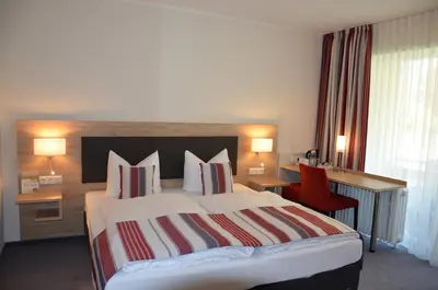 Ein Bett oder Betten in einem Zimmer der Unterkunft Flair Hotel am Rosenhügel - Garni