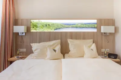 Ein Bett oder Betten in einem Zimmer der Unterkunft Eifel Hotel Schneider am Maar